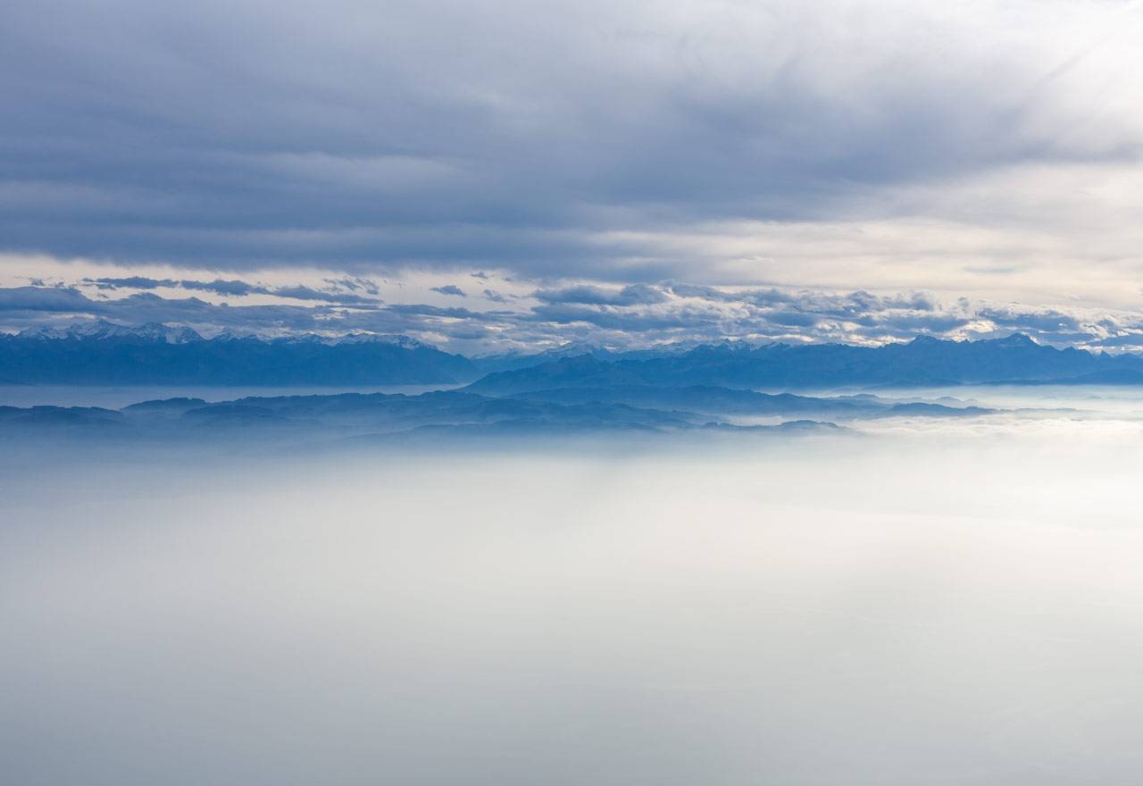 Blick auf Bodensee und Rheintal beim herbstlichen Flug zwischen Wolkendecke und Nebel